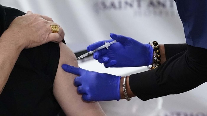 Cardinal Blase Cupich, archbishop of Chicago, blesses medical workers Wednesday, Dec. 23, 2020, after receiving the first of the two Pfizer-BioNTech COVID-19 vaccinations at Saint Anthony Hospital in Chicago. (AP Photo/Charles Rex Arbogast)