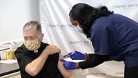 Kardinal Blase Cupich, Uskup Agung Chicago, kiri, menerima yang pertama dari dua vaksinasi Pfizer-BioNTech COVID-19 Rabu, 23 Desember 2020, dari Sherrie Spencer, Wakil Presiden Kepala Perawat di Rumah Sakit Saint Anthony di Chicago.
