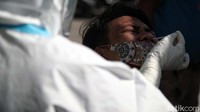 Petugas mengambil sampel air di hidung seorang penumpang.