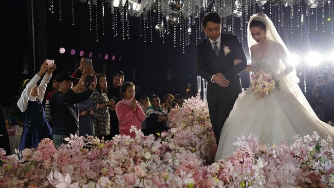 Tak sedikit pasangan pengantin di China yang kembali menggelar resepsi pernikahan di tengah pandemi COVID-19.