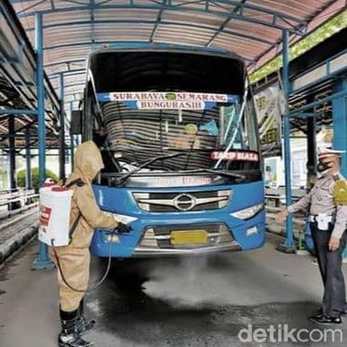 Polisi Lamongan menyemprotkan disinfektan ke bus dan kendaraan umum