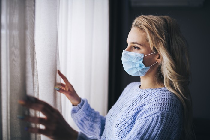 Ilustrasi pakai masker dan isolasi mandiri Blonde woman in isolation at home for virus outbreak