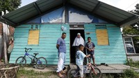 Korban tsunami Aceh 26 Desember 2004 Rian Aldiansyah (kiri) bersama keluarga berada di depan rumah sementera (shelter) yang ditempatinya di Gampong Lampaseh Kota, Banda Aceh, Aceh, Jumat (25/12/2020). ANTARA FOTO/Irwansyah Putra