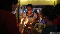Satu per satu jemaat menyalakan lilin di misa malam Natal yang digelar di rumah.