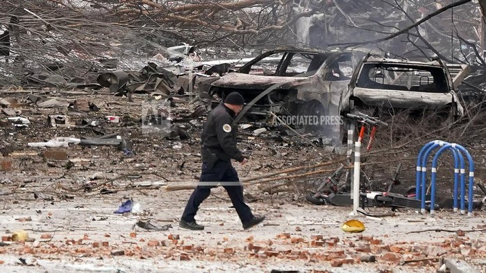 A law enforcement member walks past damage from an explosion in downtown Nashville, Tenn., Friday, Dec. 25, 2020. Buildings shook in the immediate area and beyond after a loud boom was heard early Christmas morning. (AP Photo/Mark Humphrey)