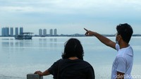 Dua orang pengunjung menikmati Pantai Maju.
