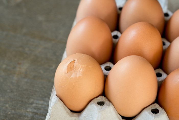 Cracked egg in paper tray,Selective fous.