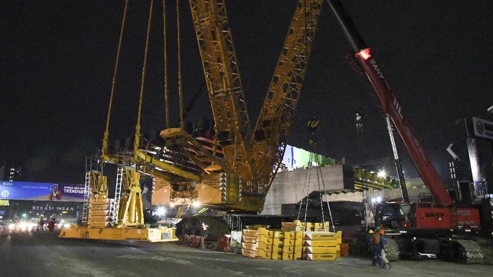 PEMASANGAN BALOK GIRDER TOL BECAKAYU SEKSI II A Sejumlah pekerja menyelesaikan pemasangan balok girder (erection girder) Tol Becakayu Seksi II A di Jalan Ahmad Yani, Bekasi, Jawa Barat, Minggu (27/12/2020) dini hari. Pemasangan balok girder proyek jalan Tol Becakayu (Bekasi, Cawang, Kampung Melayu) seksi II A sepanjang 4,1 km dari Jakasampurna menuju Bekasi Timur tersebut dilaksanakan dari tanggal 18 Desember-8 Januari 2020 pukul 23.00 - 04.00 WIB dengan memperhatikan keamanan dan keselamatan pengguna jalan. ANTARA FOTO/Fakhri Hermansyah/rwa.