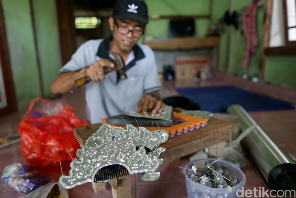 Nasabah KUR Mikro BRI, Ade Sanjaya yang juga penyintas Disabilitas menyelesaikan kerajinan Sugu Tinggi Iban di kediamannya, Badau, Kalimantan Barat. Dari hasil kerajinannya itu, ia bisa meraih Omzet Rp 5 juta per/bulan. Sebagian besar Sugu Tinggi itu di ekspor ke negara tetangga Malaysia dan Brunei Darussalam dan juga ke dalam negeri atau warga sekitar.