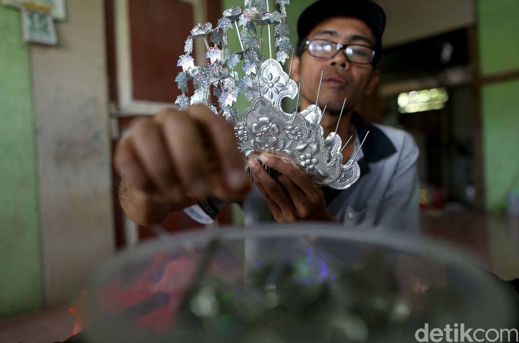 Nasabah KUR Mikro BRI, Ade Sanjaya yang juga penyintas Disabilitas menyelesaikan kerajinan Sugu Tinggi Iban di kediamannya, Badau, Kalimantan Barat. Dari hasil kerajinannya itu, ia bisa meraih Omzet Rp 5 juta per/bulan. Sebagian besar Sugu Tinggi itu di ekspor ke negara tetangga Malaysia dan Brunei Darussalam dan juga ke dalam negeri atau warga sekitar.