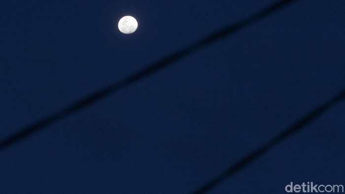 Penampakan bulan di langit terlihat pada sore hari, Minggu (27/12) di wilayah Depok, Jawa Barat setelah diguyur hujan selama kurang lebih satu jam
