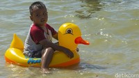 Seorang anak asyik berenang.