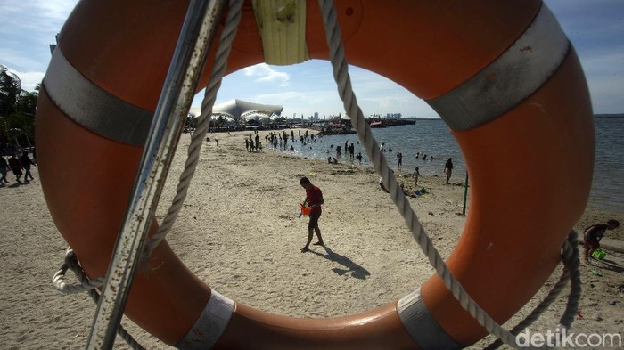 Warga mengisi libur Nataru ini dengan pengunjungi Ancol. Mereka bermain bersama keluarga di Pantai Ancol.
