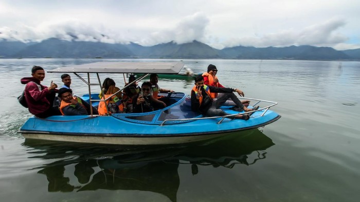 Pengunjung berkeliling menggunakan speed boat di kawasan wisata Laut Tawar, Aceh Tengah, Aceh, Minggu ( 27/12/2020). Kawasan wisata alam tersebut ramai dikunjungi wisatawan untuk menikmati musim libur akhir tahun 2020. ANTARA FOTO/Rahmad/rwa.