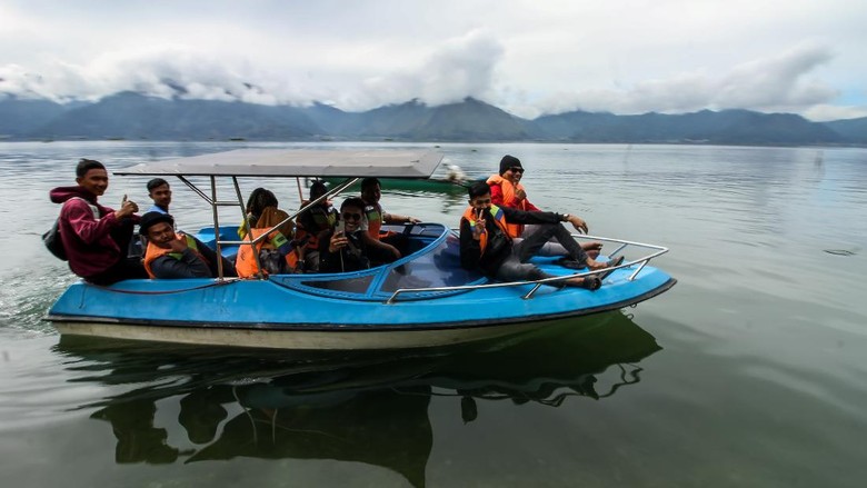 Pengunjung berkeliling menggunakan speed boat di kawasan wisata Laut Tawar, Aceh Tengah, Aceh, Minggu ( 27/12/2020). Kawasan wisata alam tersebut ramai dikunjungi wisatawan untuk menikmati musim libur akhir tahun 2020. ANTARA FOTO/Rahmad/rwa.