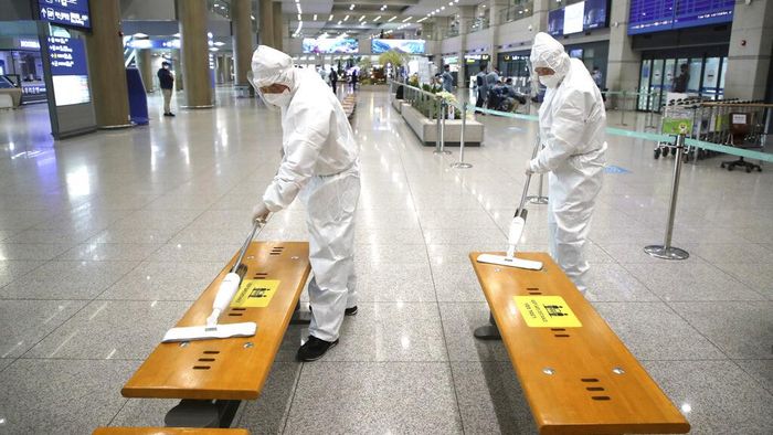 Deretan Negara yang Dilanda Varian Baru Virus Corona Workers wearing protective gears disinfect chairs as a precaution against the coronavirus at the arrival hall of the Incheon International Airport in Incheon, South Korea, Monday, Dec. 28, 2020. South Korea has confirmed its first cases of a more contagious variant of COVID-19 that was first identified in the United Kingdom. (Kim Sun-woong/Newsis via AP)