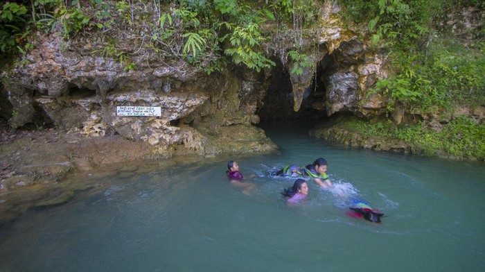Wisatawan berenang di goa Liang Tapah di Desa Geragata, Kabupaten Tabalong, Kalimantan Selatan, Minggu (27/12/2020). Goa Liang Tapah merupakan salah satu wisata alam yang termasuk geosite di wilayah Geopark Meratus di Provinsi Kalimantan Selatan yang ramai dikunjungi wisatawan saat hari libur. ANTARA FOTO/Bayu Pratama S/pras.