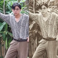 Dalam tantangan foto jadul ala 90-an ini, Rey Mbayang bergaya memakai kemeja klasik dipadu dengan celana panjang cokelat. Agar lebih dramatisir, Rey juga memakai kacamata bulat sambil bergaya tanpa ekspresi. Foto: Instagram @dindahw.