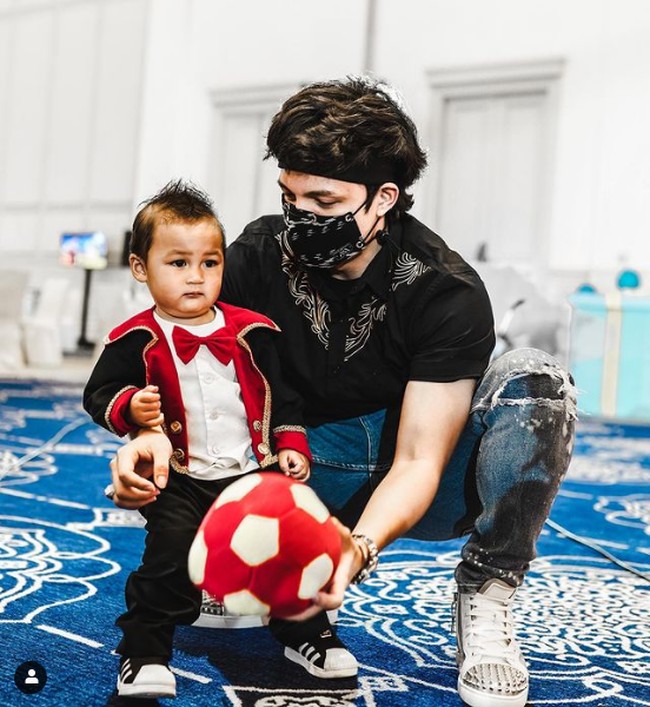 Atta Halilintar bergaya dengan kaus hitam dan celana denim sobek saat hadir di ulang tahun anak Baim Wong yang disiarkan live di YouTube tersebut. udah cocok jadi PAPA Belum? begitu Atta menulis di keterangan fotonya bersama Kiano yang berulang tahun ke-1. Foto: Instagram