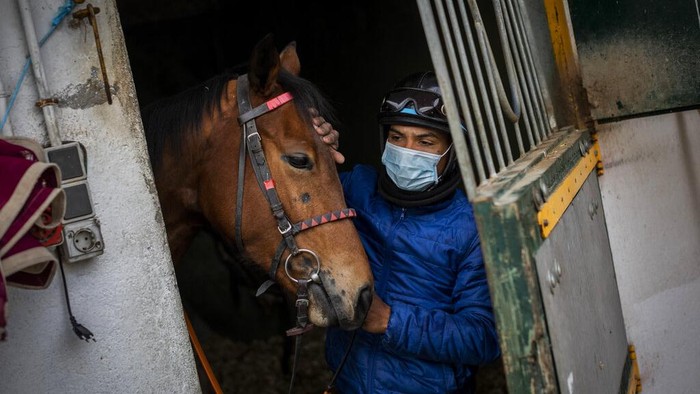 Pacuan Kuda di Spanyol Tetap Bertahan di Tengah Pandemi Turf horse race aficionados follow a race at the Hipodromo de la Zarzuela outskirts of Madrid, Spain, Sunday, Dec. 6, 2020. The pandemic may have altered many habits but horse racing at the Zarzuela has changed little. (AP Photo/Bernat Armangue)