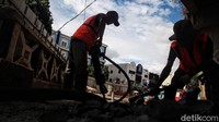 Pekerja meratakan tanah yang akan dibangun Plaza Stasiun Tebet.