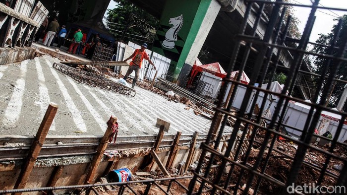 Sejumlah pekerja merampungkan pengerjaan bangunan dalam proyek penataan plaza Stasiun Tebet di kolong jembatan layang Tebet, Jakarta Selatan, Selasa (29/12/2020). Stasiun Tebet akan ditata layaknya Stasiun Tanah Abang untuk mengoptimalkan integrasi antarmoda bagi penumpang yang mengakses transportasi kereta api.