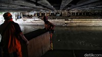 Petugas PPSU terlihat memindahkan barang-barang bangunan.