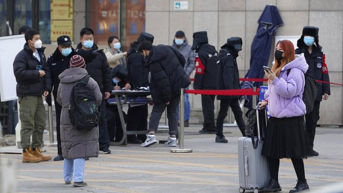Residents line up for coronavirus tests at tents set up on the streets of Beijing on Sunday, Dec. 27, 2020. Beijing has urged residents not to leave the city during the Lunar New Year holiday in February, implementing new restrictions and mass testings after several coronavirus infections last week. (AP Photo/Ng Han Guan)