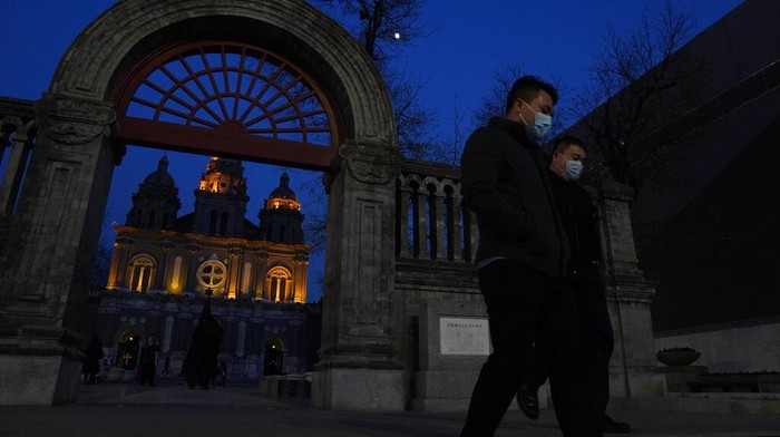 Residents line up for coronavirus tests at tents set up on the streets of Beijing on Sunday, Dec. 27, 2020. Beijing has urged residents not to leave the city during the Lunar New Year holiday in February, implementing new restrictions and mass testings after several coronavirus infections last week. (AP Photo/Ng Han Guan)