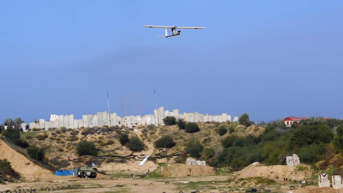 Palestinian militants use a drone to film during a military drill organized by military factions outside Gaza City, Tuesday, Dec. 29, 2020. Palestinian militants in the Gaza Strip fired a salvo of rockets into the Mediterranean Sea on Tuesday as part of a self-styled military drill aimed at preparing for a possible war with Israel. (AP Photo/Adel Hana)