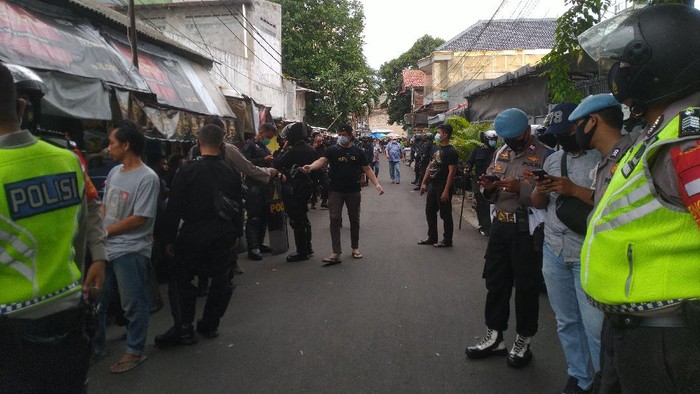 TNI dan pasukan Brimob mencabut spanduk Habib Rizieq Shihab dan Front Pembela Islam (FPI) di Petamburan, Jakarta Pusat (Jakpus). Petugas gabung langsung melakukan penjagaan di kawasan Petamburan, Jakarta Pusat usai mencabut spanduk FPI.