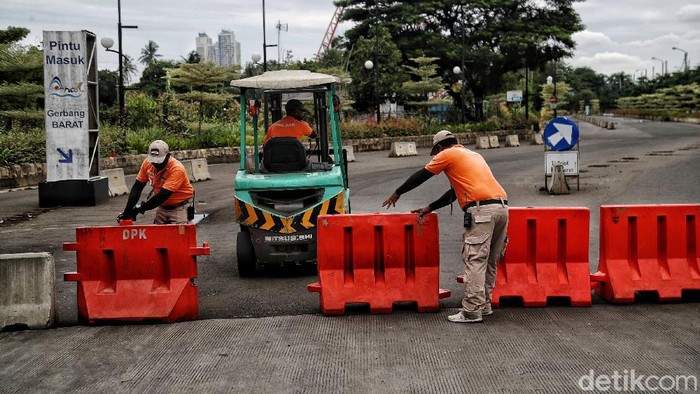 Ancol Tutup Saat Perayaan Tahun Baru 2021 Petugas keamanan berjaga jalan menuju gerbang Ancol, Jakarta Utara, Kamis (31/12). PT Taman Impian Jaya Ancol memutuskan untuk menutup kawasan wisata Ancol pada saat Hari Raya Natal 25 Desember 2020. Penutupan juga kembali dilakukan pada saat Periode Tahun Baru 2021 mulai 31 Desember-1 Januari 2021.