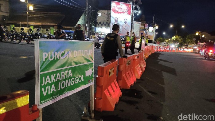Petugas menutup jalur dari arah Cianjur menuju Puncak jelang malam pergantian tahun.