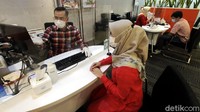 Petugas customer service sedang melayani nasabah pada operasional terbatas BNI di Jakarta. 
