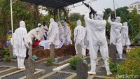 Proses upacara pemakaman dilakukan oleh personel TNI yang memakai pakaian hazmat.