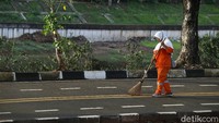Seorang pasukan oranye sebutan populer untuk pekerja Penanganan Prasaran dan Sarana Umum (PPSU), membersihkan sampah di kawasan Kanal Banjir Timur (KBT), Jakarta Timur, Jumat, (01/01/2021).