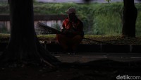 Seorang petugas kebersihkan tengah beristirahat setelah bekerja.