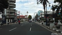 Jalan Asia Afrika yang merupakan jantung Kota Bandung. Tak banyak kendaraan yang melintas di hari pertama 2021. Namun, di trotoar masih terlihat sejumlah orang melakukan aktivitasnya. 