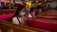 Warga juga tampak memegang bunga saat mengikuti upacara pemakaman tradisional itu.  