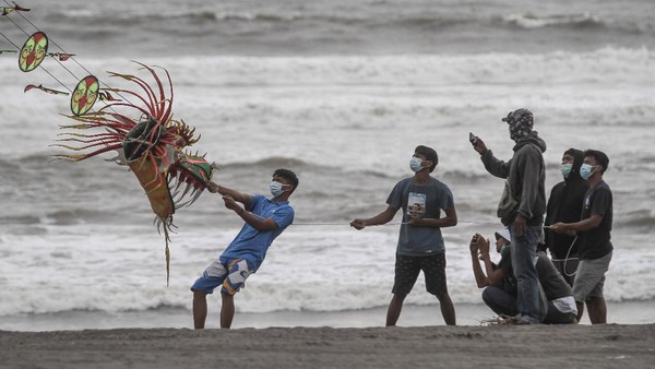 Guna mengantisipasi penyebaran virus Corona, para wisatawan yang datang berkunjung ke Pantai Parangkusumo tampak mengenakan masker.