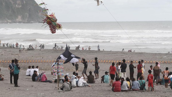 Sejumlah wisatawan mengunjungi objek wisata Pantai Parangkusumo di Bantul, DI Yogyakarta, Jumat (1/1/2021).
