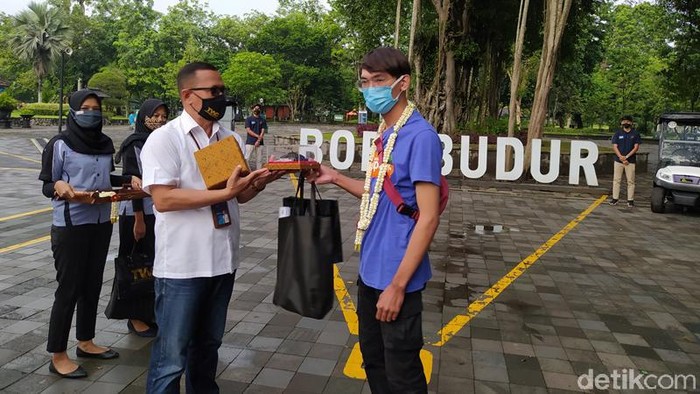 Pemberian suvenir kepada pengunjung pertama Candi Borobudur di awal tahun 2021