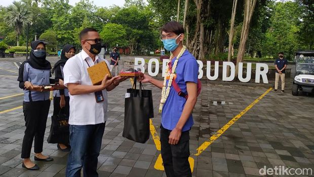 Pemberian suvenir kepada pengunjung pertama Candi Borobudur di awal tahun 2021