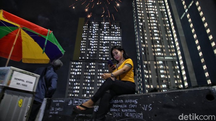 Wisma Atlet Pukul 00.00 WIB Sejumlah warga menyalakan petasan dan kembang api di depan Rumah Sakit Darurat (RSD) Penanganan Covid-19 Kompleks Wisma Atlet Kemayoran saat malam pergantian tahun.