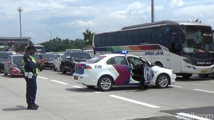 Petugas menutup jalan Tol Cikampek.
