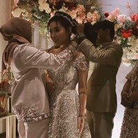 Ia pun terlihat memasangkan kalung di leher calon menantunya tersebut sambil dibantu oleh Reza. (Foto: Instagram)