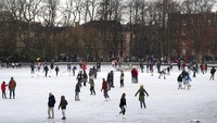 Orang-orang berjalan dan berseluncur es di kolam beku di Queens Park di Glasgow. Andrew Milligan/PA via AP  