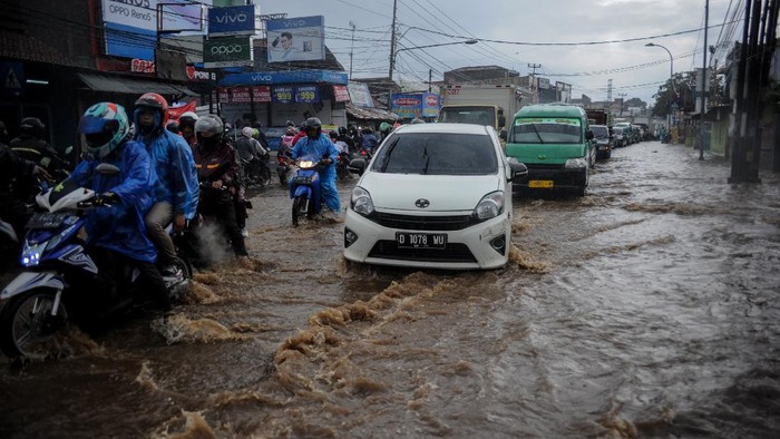 DRAINASE BURUK DI KABUPATEN BANDUNG Kendaraan menerjang air yang menggenangi Jalan Raya Cinunuk, Kabupaten Bandung, Jawa Barat, Senin (4/1/2021). Genangan air setinggi 10 hingga 50 sentimeter menggenangi Jalan Nasional menuju Sumedang, Tasik dan Garut akibat drainase yang buruk sehingga tidak dapat menampung debit air secara maksimal saat hujan lebat mengguyur kawasan Bandung Raya. ANTARA FOTO/Raisan Al Farisi/foc.
