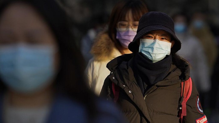Jelang Libur Imlek, China Desak Warganya Tidak Mudik People wearing face masks to help curb the spread of the coronavirus walk through commercial office buildings in Beijing, Monday, Jan. 4, 2021. Wary of another wave of infections, China is urging tens of millions of migrant workers to stay put during next month's Lunar New Year holiday, usually the world's largest annual human migration. (AP Photo/Andy Wong)