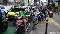 Tak sendiri, sejumlah pemotor ini menerobos trotoar ramai-ramai.